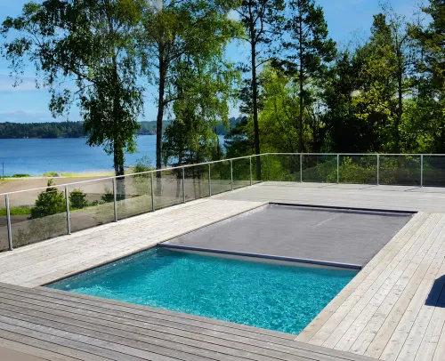 Automatiskt poolskydd med tät duk halvvägs över poolen – sluter tätt mot vattenytan