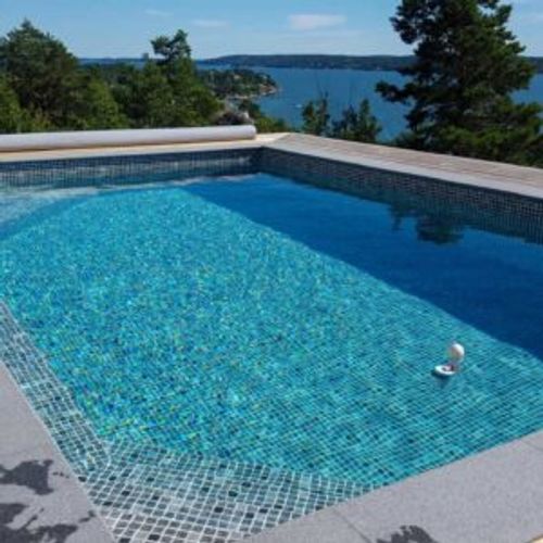 Pool i skärgårdsmiljö med mosaikliner, trappa och sjöutsikt